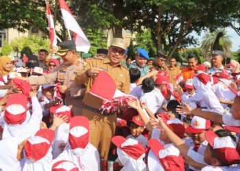 Penjabat Wali Kota Lhokseumawe, A. Hanan, bersama Forkopimda membagikan bendera merah putih kepada para siswa