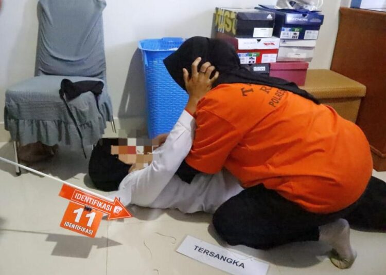 Tersangka berinisial W memperagakan salah satu dari 16 adegan dalam rekonstruksi pembunuhan istri dokter di Lhokseumawe, Senin (11/11/2024) pagi.