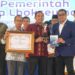 Menteri Ekonomi Kreatif Republik Indonesia, Teuku Riefky Harsya, didampingi oleh Pimpinan Perusahaan Serambi Indonesia, Mohd Din, menyerahkan penghargaan Serambi Ekraf Awards 2025 kepada Wali Kota Lhokseumawe, Sayuti Abubakar