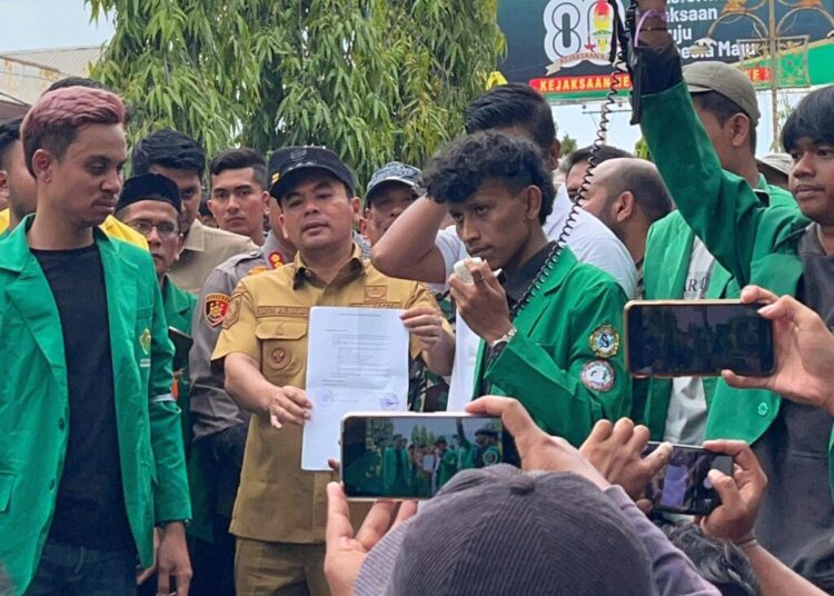 Wali Kota Lhokseumawe, Sayuti Abubakar, saat menemui mahasiswa dalam unjuk rasa di depan Kantor DPRK Lhokseumawe