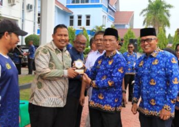 Sekda Lhokseumawe, A. Haris, S.Sos., M.Si., menyerahkan plakat penghargaan kepada 16 cabor yang dianggap telah berdedikasi dalam memajukan dunia olahraga dalam peringatan Haornas ke-42 di Lhokseumawe.