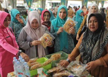 Ketua TP PKK Kota Lhokseumawe, Ny. Yulinda Sayuti, menyapa para pedagang dan pelaku UMKM dalam kegiatan Pasar Tani dan Gerakan Pangan Murah di Desa Mon Geudong, Kecamatan Banda Sakti, Selasa (14/10/2025).