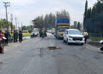 Petugas Satlantas Polres Lhokseumawe melakukan olah TKP di lokasi kecelakaan maut antara sepeda motor dan truk di Desa Tambon Baroh, Aceh Utara, Rabu (15/10/2025).