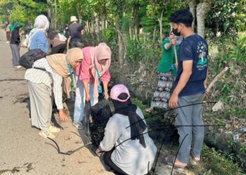 Mahasiswa KKN Kelompok 67 Universitas Malikussaleh bersama warga Gampong Kumbang Punteut bergotong royong membersihkan area Meunasah