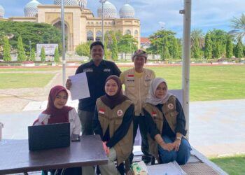 Relawan KSR PMI Unit 08 UIN SUNA Lhokseumawe melakukan pemeriksaan data dan skrining kesehatan kepada peserta donor darah di Lapangan Hiraq, Lhokseumawe