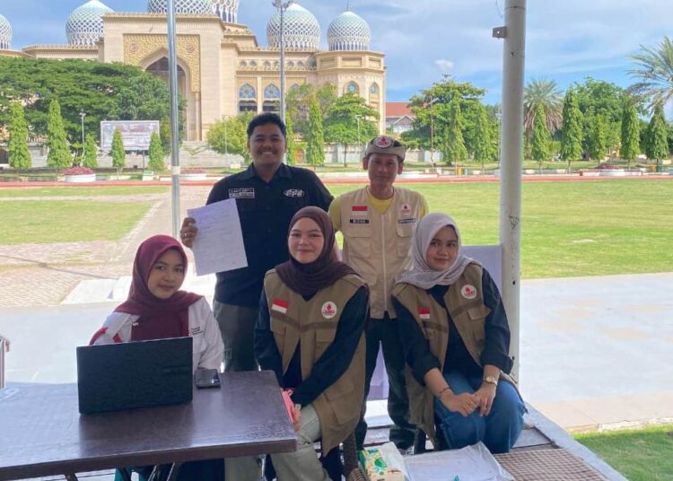 Relawan KSR PMI Unit 08 UIN SUNA Lhokseumawe melakukan pemeriksaan data dan skrining kesehatan kepada peserta donor darah di Lapangan Hiraq, Lhokseumawe